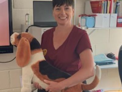 Ruth Fagan holding dog soft toy in classroom