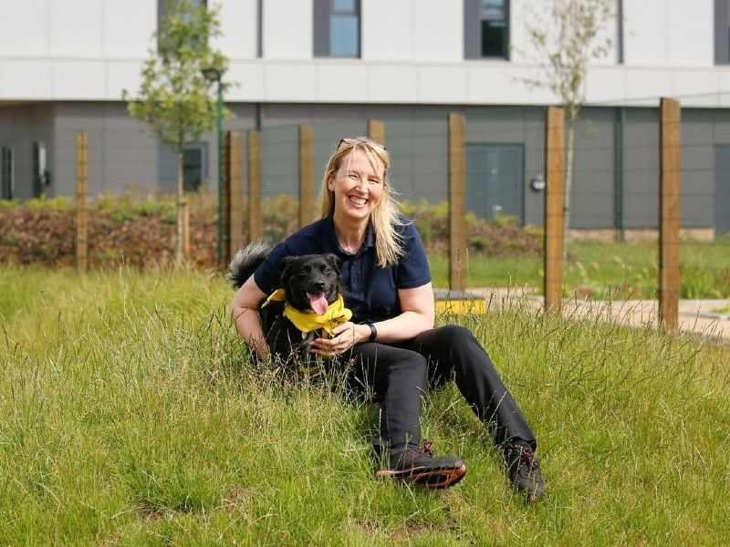 Centre manager sitting on grass with dog