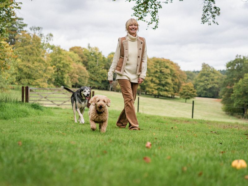 Clodagh McKenna walking in a field along side her two dogs.